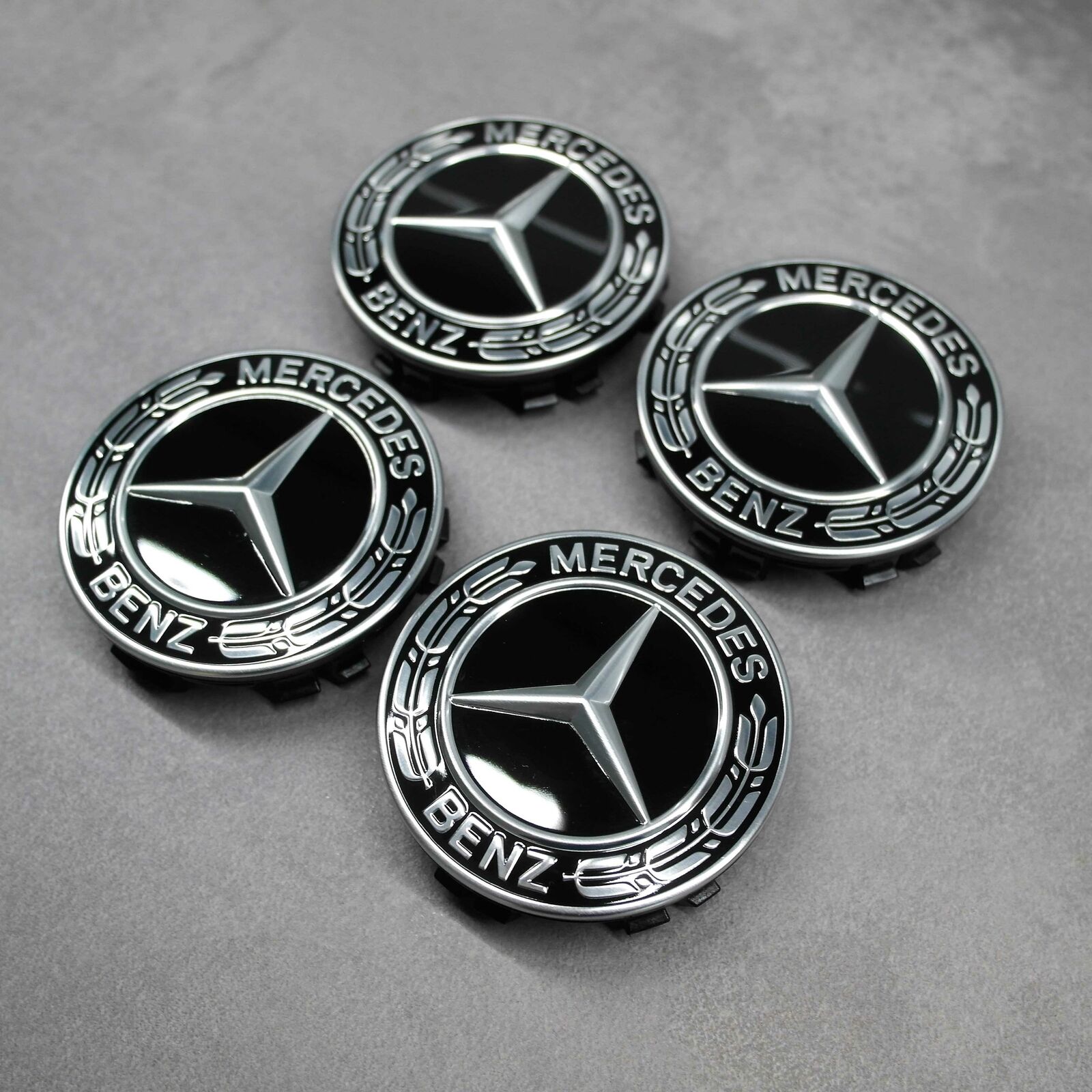 Detailaufnahme des Lorbeerkranzes und Mercedes-Benz-Logos auf dem schwarzen Nabendeckel, Original, Durchmesser 66,8 mm.